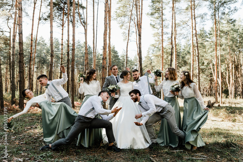 a group of cheerful and happy people of different nationalities laughing having fun with a young bride and groom on their wedding day,positive large group of friends