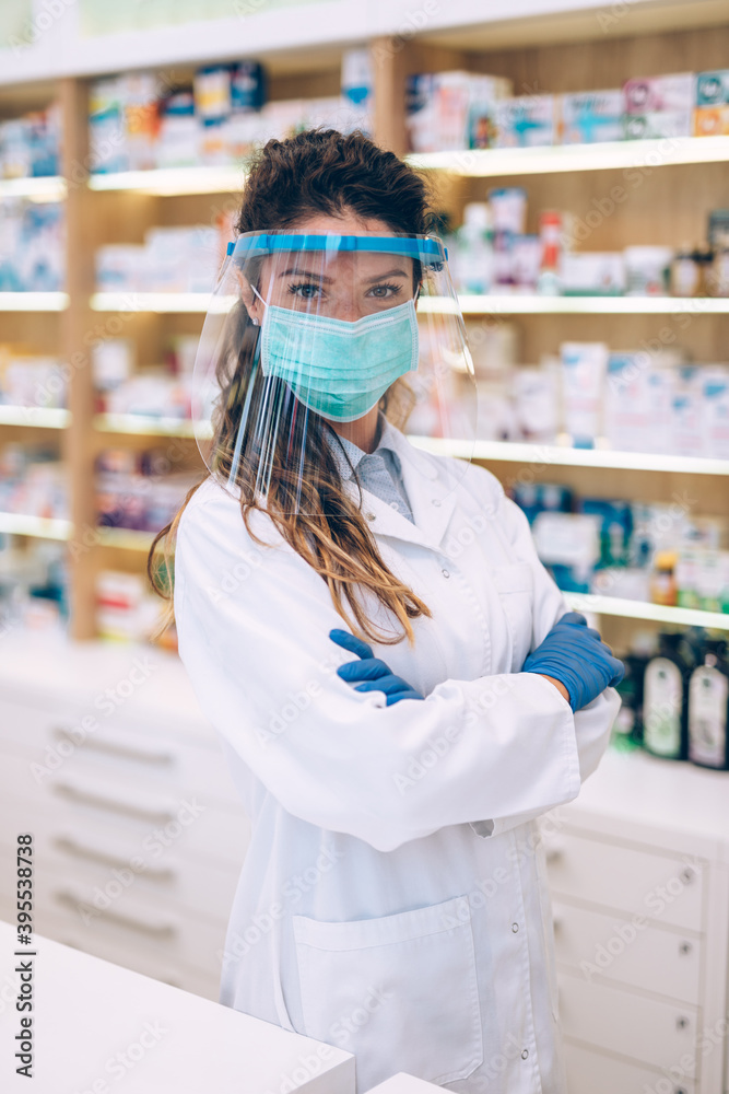 Female pharmacist with protective mask and face shield on her face ,working at pharmacy. Medical healthcare concept. Female pharmacist with protective mask and face shield on her face ,working at pharmacy. Medical healthcare concept.