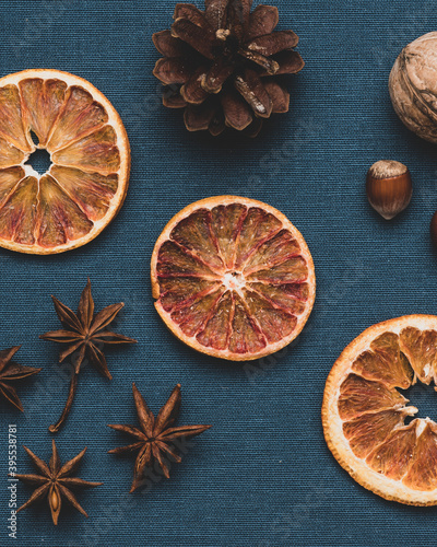 Pieces of dried oranges . And also a fir cone on a dark blue fabric background