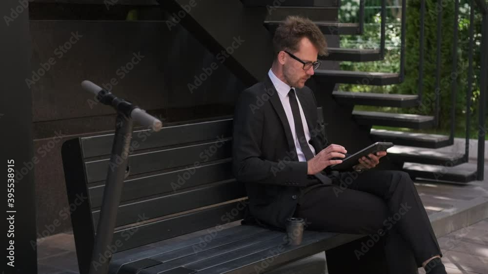 office worker is using tablet with internet at break time on street office worker is using tablet with internet at break time on street