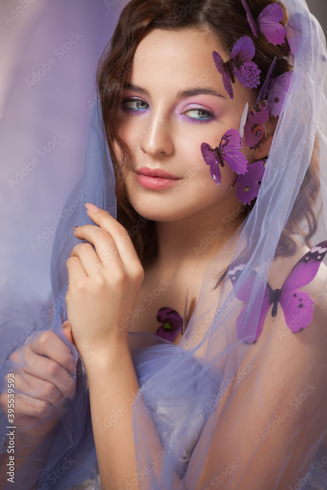 Beautiful young woman with artificial butterfly in curly hair. Beautiful young woman with artificial butterfly in curly hair.