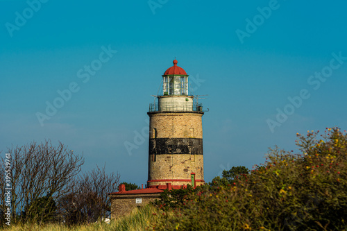 A brick lighthouse with a bright blue sky in the background. Picture of Falsterbo Lighthouse built in 1796  Scania  Sweden