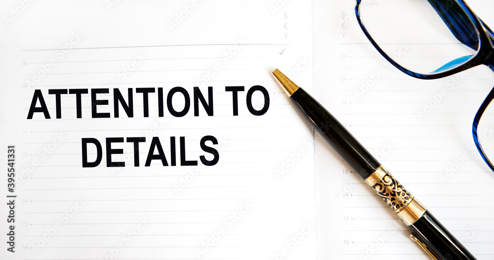 In the diary, the inscription ATTENTION TO DETAILS, next to a pen and glasses. In the diary, the inscription ATTENTION TO DETAILS, next to a pen and glasses.