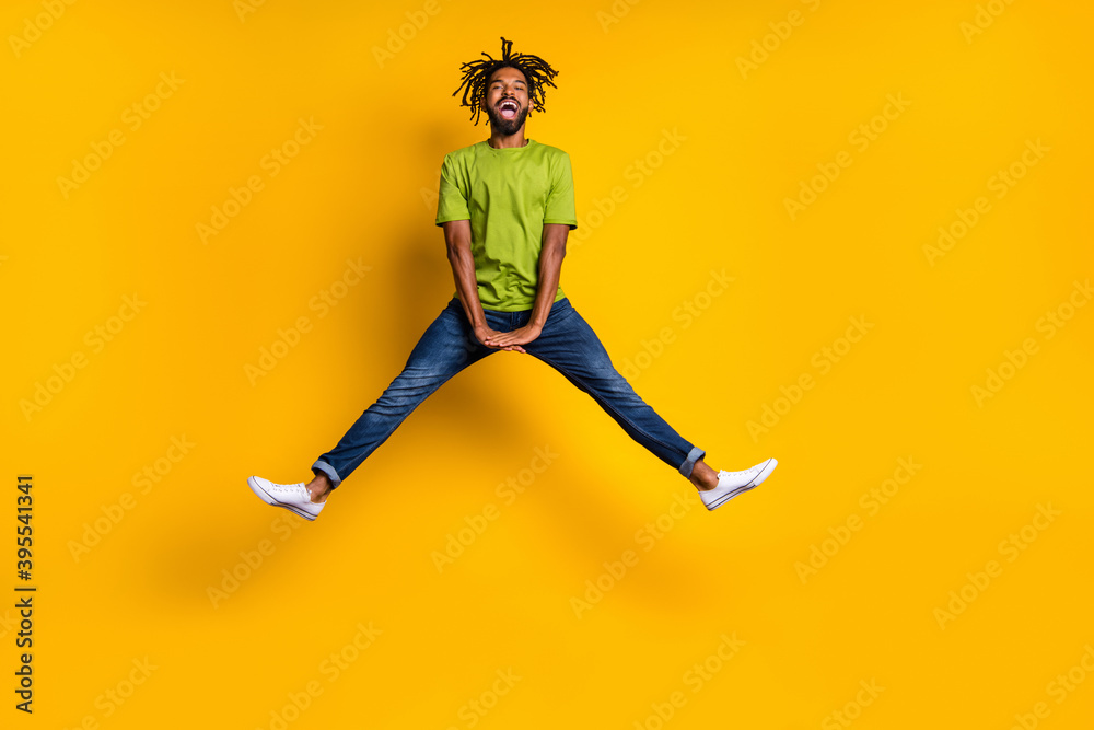 Full Length Photo Portrait Of Guy Jumping Up Spreading Legs Isolated On Vivid Yellow Colored