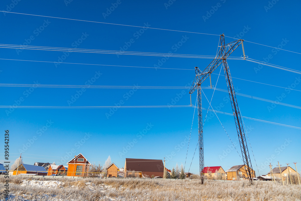 Snow-covered winter road with power line in the field in Siberia, Russia Snow-covered winter road with power line in the field in Siberia, Russia