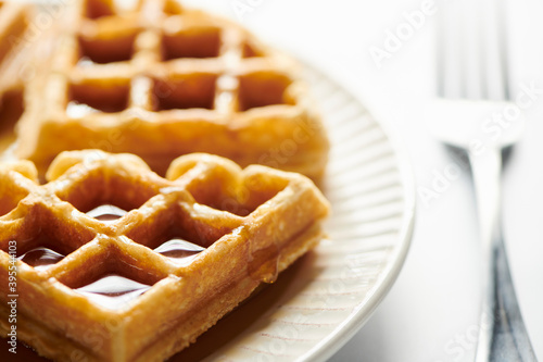 Belgian waffle pieces with syrup drpping down side photo