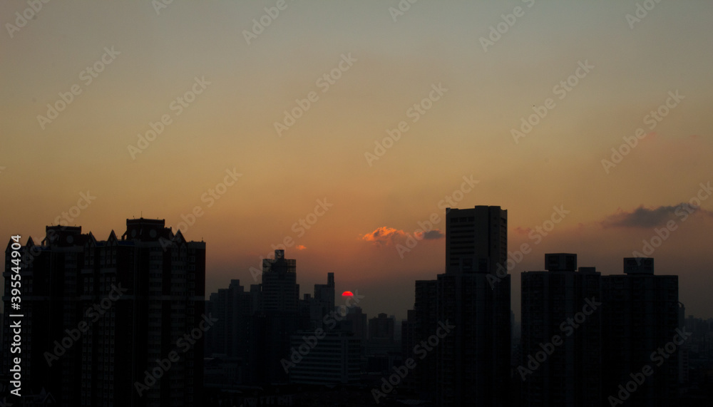 The sun sets behind the Shanghai skyline