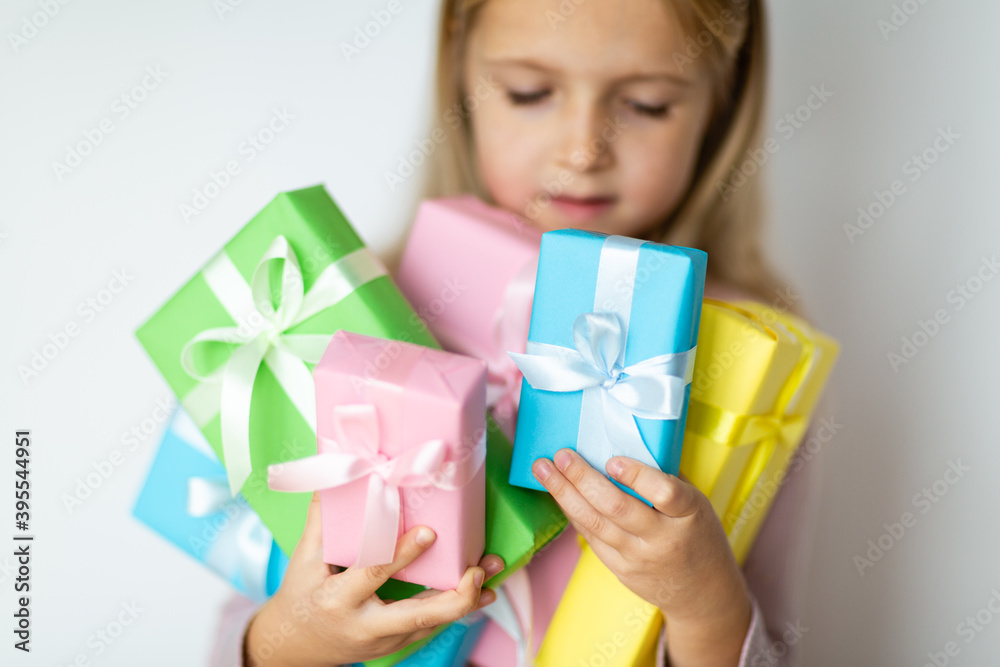 Happy kid receiving present on boxing day. Little girl smiling with wrapped present box. Small child in pink hat holding birthday gift isolated on white background. Holiday, celebration concept Happy kid receiving present on boxing day. Little girl smiling with wrapped present box. Small child in pink hat holding birthday gift isolated on white background. Holiday, celebration concept