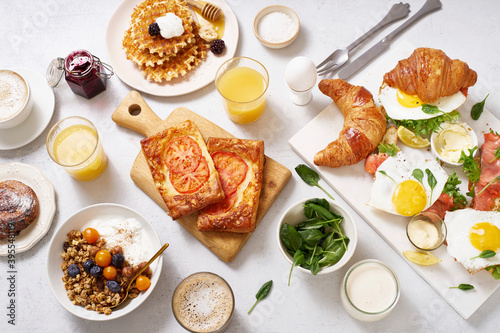 Healthy sunday breakfast with croissants, waffles, eggs, granola and sandwiches