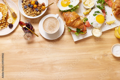 Healthy sunday breakfast with croissants, waffles, granola and sandwiches photo