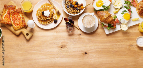 Healthy sunday breakfast with croissants, waffles, granola and sandwiches photo