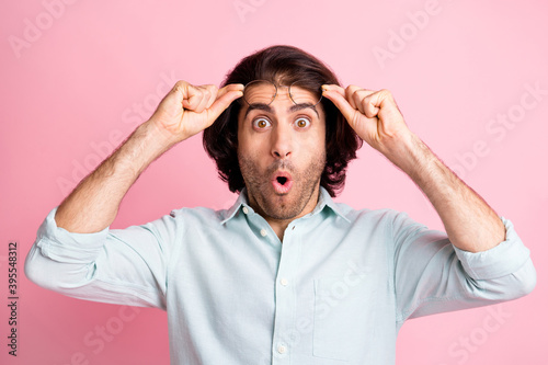 Close up portrait of astonished young man arms hold glasses open mouth unexpected news isolated on pink color background