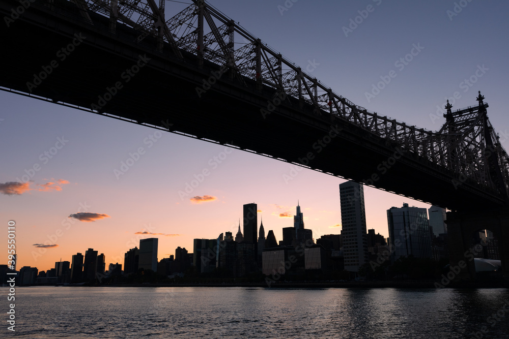The Queensboro Bridge with a Silhouette of the Manhattan Skyline during Sunset along the East River in New York City