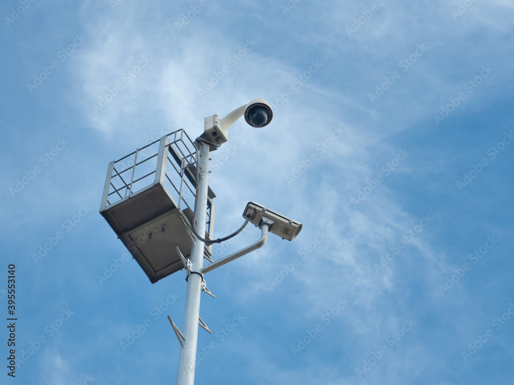 360 Degree fish eye dome CCTV and CCTV camera are installed on column against blue sky. 360 Degree fish eye dome CCTV and CCTV camera are installed on column against blue sky.