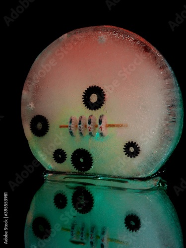 Fototapeta Naklejka Na Ścianę i Meble -  counter that shows 2021 and gears frozen in ice in abstract macro photography