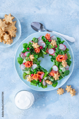 Salad in form of wreath with salmon, cucumber, radish, peas, corn and cheese cookies stars photo