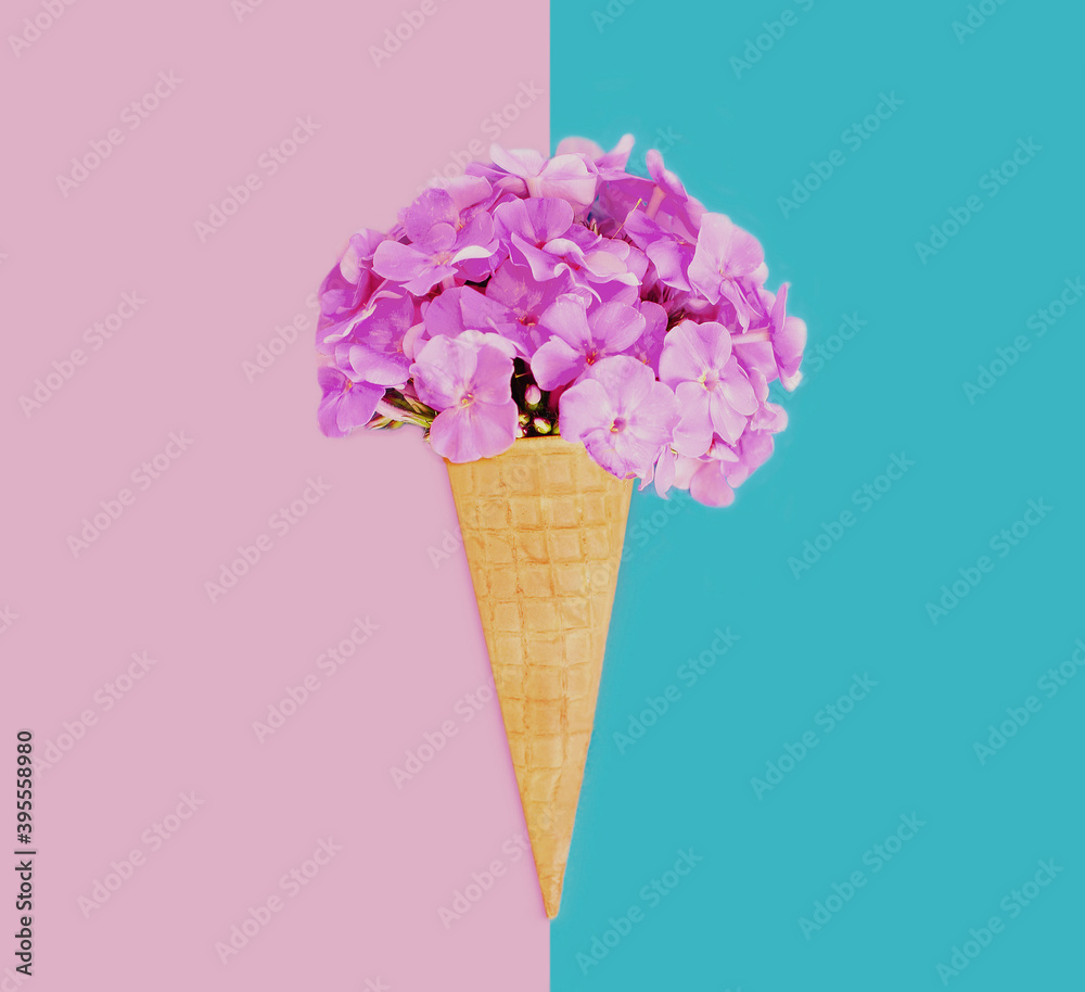 =Stylish image of cone with pink flowers as ice cream over a blue background =Stylish image of cone with pink flowers as ice cream over a blue background