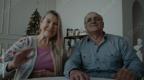 POV webcam view, Senior mature adult Caucasian couple having a video call with friends or family on Christmas eve. Holidays celebration during COVID-19 Coronavirus lockdown