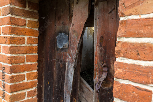 Old wooden doors in a destroyed building and a hole in them