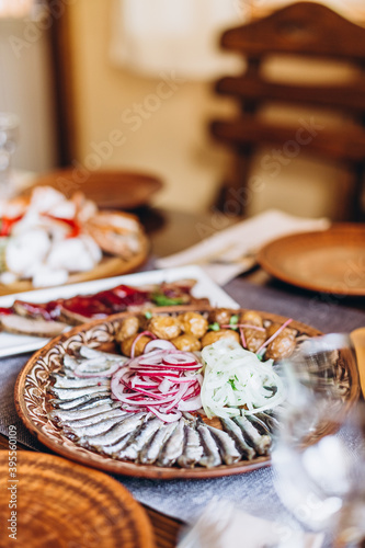 home wooden table covered with plates with various delicious dishes in the Slavic style  sourdough  salted and fried fish  potatoes  fried meat and salads
