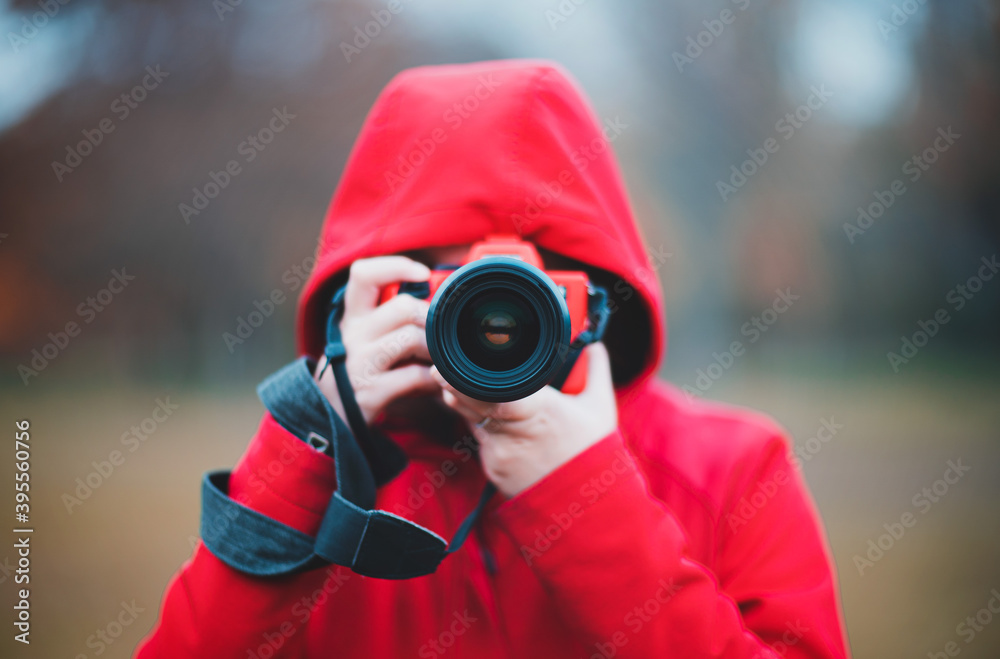 Photographer in center taking photo with lens and red hoodie rainy autumn day Photographer in center taking photo with lens and red hoodie rainy autumn day