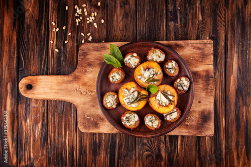 Grilled baked peach and plums stuffed with blue cheese dorblu and rosemary photo