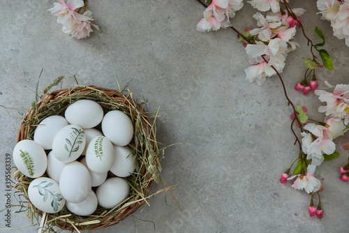 Painted Easter eggs in an Easter basket and a blooming cherry branch photo