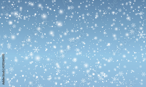 Snow background. Winter snowfall. White snowflakes on blue sky. Christmas background. Falling snow.