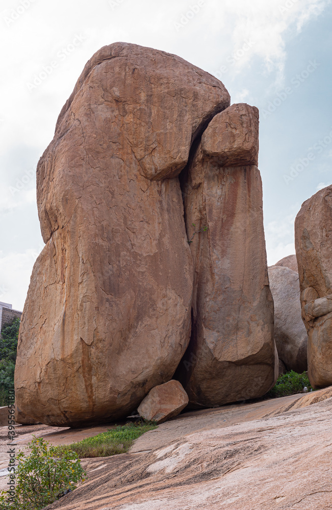 Hampi, Karnataka, India - November 4, 2013: Virupaksha Temple complex. Closeup of giant brown boulder sitting on slanted plateau above said temple. Hampi, Karnataka, India - November 4, 2013: Virupaksha Temple complex. Closeup of giant brown boulder sitting on slanted plateau above said temple.