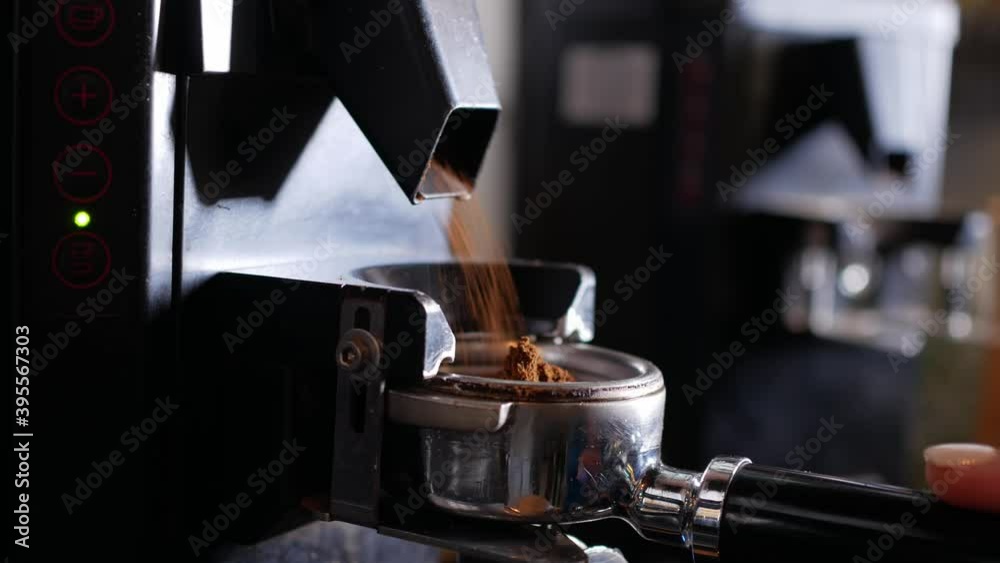 Freshly ground coffee beans in a portafilter by the coffee grinder