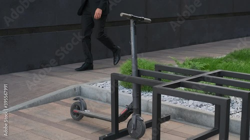 Unrecognizable male taking electric scooter in order to ride it