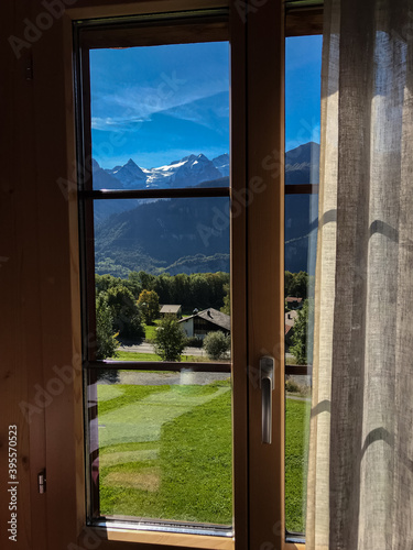 View from the window with a beautiful view of the mountains. Sunny day with blue sky in the mountains of Switzerland with magnificent views of the snowy Alps and Lauterbrunnen. 