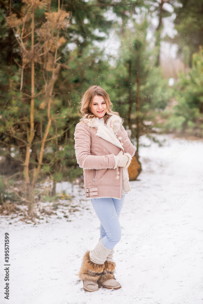 Beautiful young woman in jeans and pink jacket in winter forest Beautiful young woman in jeans and pink jacket in winter forest