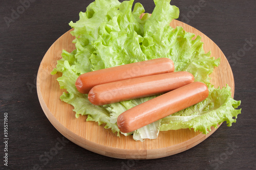smoked sausages with lettuce leaves on crumpled paper
