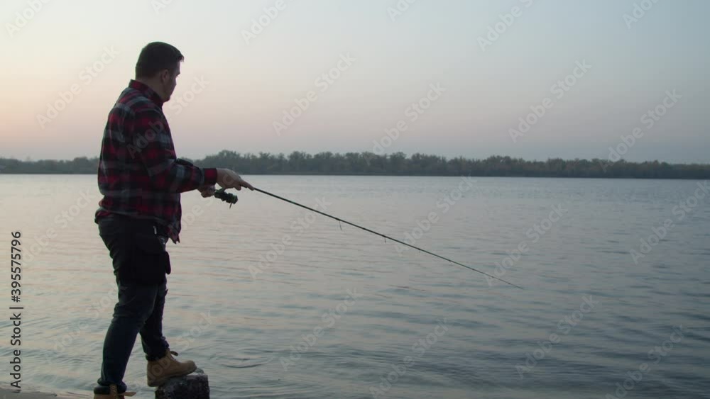 Male angler taking selfie with fish near water Male angler taking selfie with fish near water