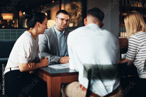 Businesspeople talking around a cafe table