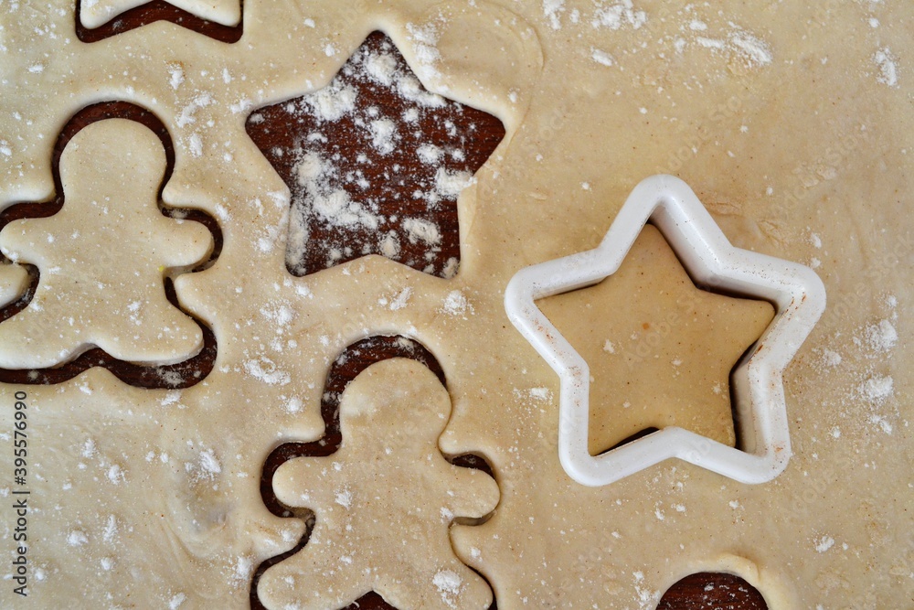 Christmas cookie dough stretched and cut with molds in the shape of a gingerbread man and stars Christmas cookie dough stretched and cut with molds in the shape of a gingerbread man and stars