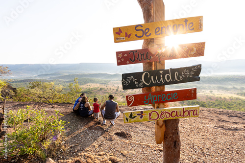 Uma linda família reunida no mirante do limpão admirando o nascer do sol. Ponto turístico, letreiros e placas de turismo