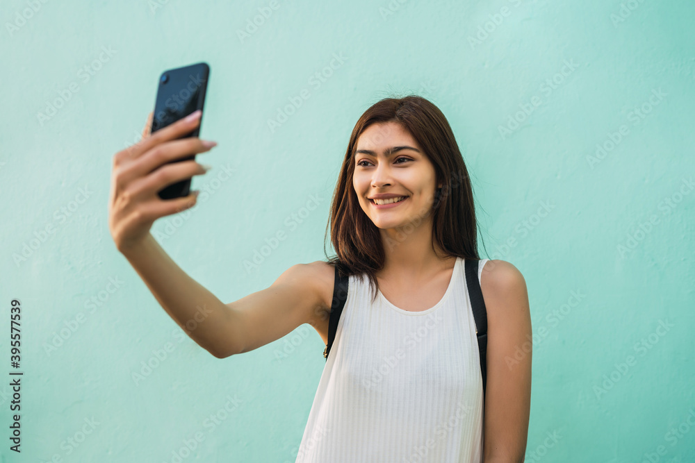 Young woman taking selfies with phone.