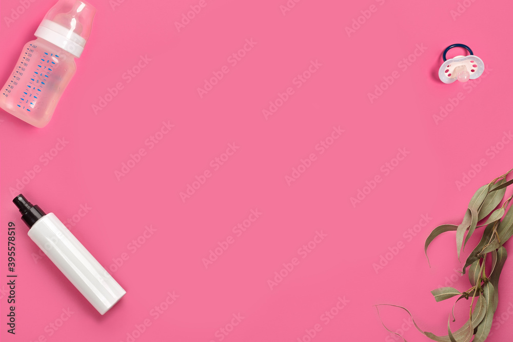 Baby bottle with nipple, pacifier, pump or spray bottle with no logo and green twig on pink studio background. Close up, copy space. Top view Baby bottle with nipple, pacifier, pump or spray bottle with no logo and green twig on pink studio background. Close up, copy space. Top view