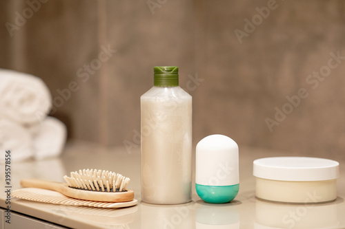 Hair care products on a wooden table on a neutral background. 