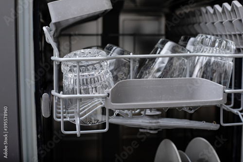 Open dishwasher with clean utensils in it