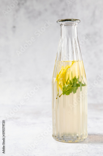 Cold peppermint tea with lemon in a glass bottle