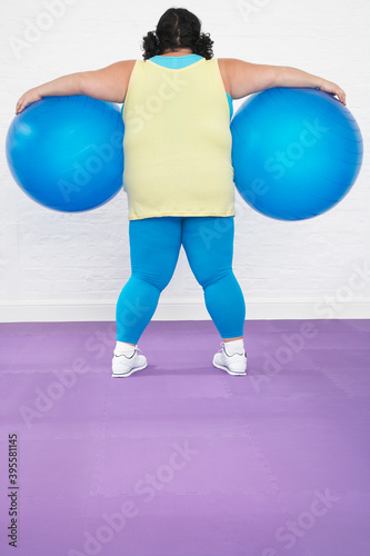 Overweight Woman Holding Two Exercise Balls