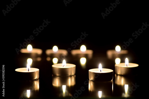 Many burning candles in the dark with bokeh effect