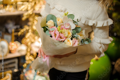 Beautiful and lovely bouquet of flowers and eucalyptus wrapped paper in the hands of woman.