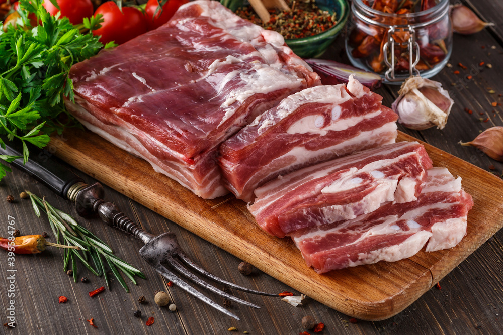 fat bacon on a wooden board. Close-up fat bacon with garlic and spices, homemade lard,Slices of bacon on a cutting Board. Pork meat. fat bacon on a wooden board. Close-up fat bacon with garlic and spices, homemade lard,Slices of bacon on a cutting Board. Pork meat.