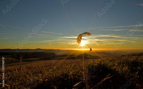 Ein fliegender Paraglider fliegt im Sonnenuntergang 