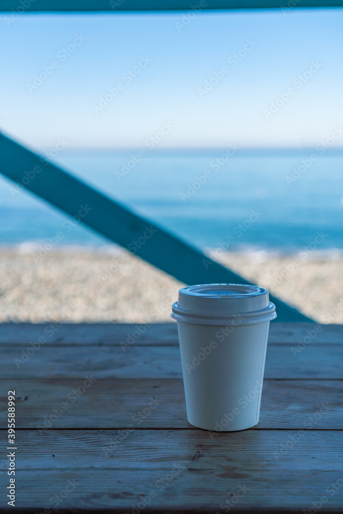 a paper cup of coffee stands by the sea a paper cup of coffee stands by the sea