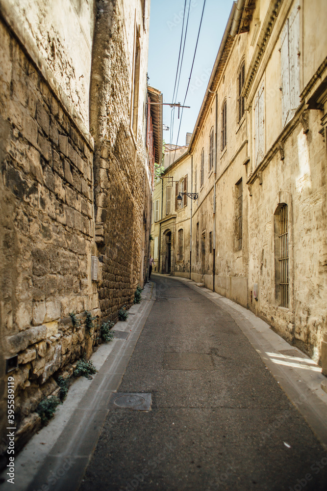 narrow street in the town in sunny day, Houses with large old stone walls